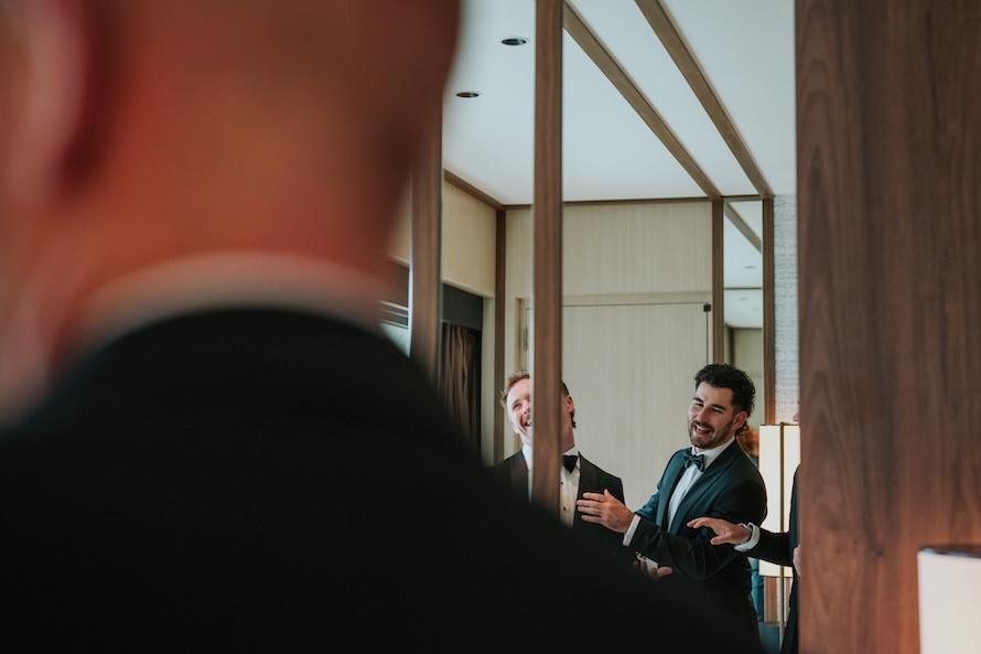 groom and groomsmen enjoying a joke during tie wearing